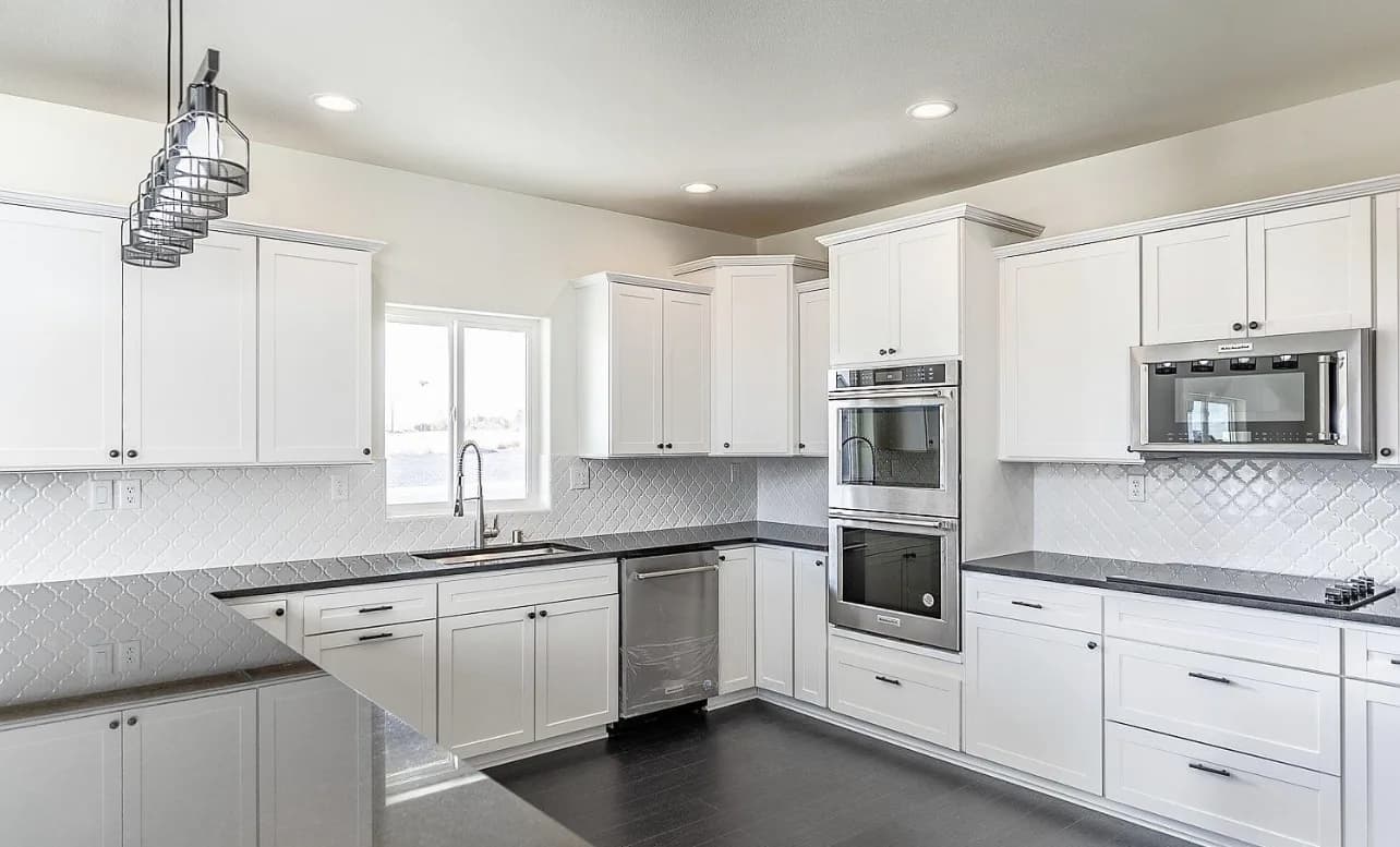 White shaker kitchen with arabesque backsplash and industrial pendant cluster - photo 1