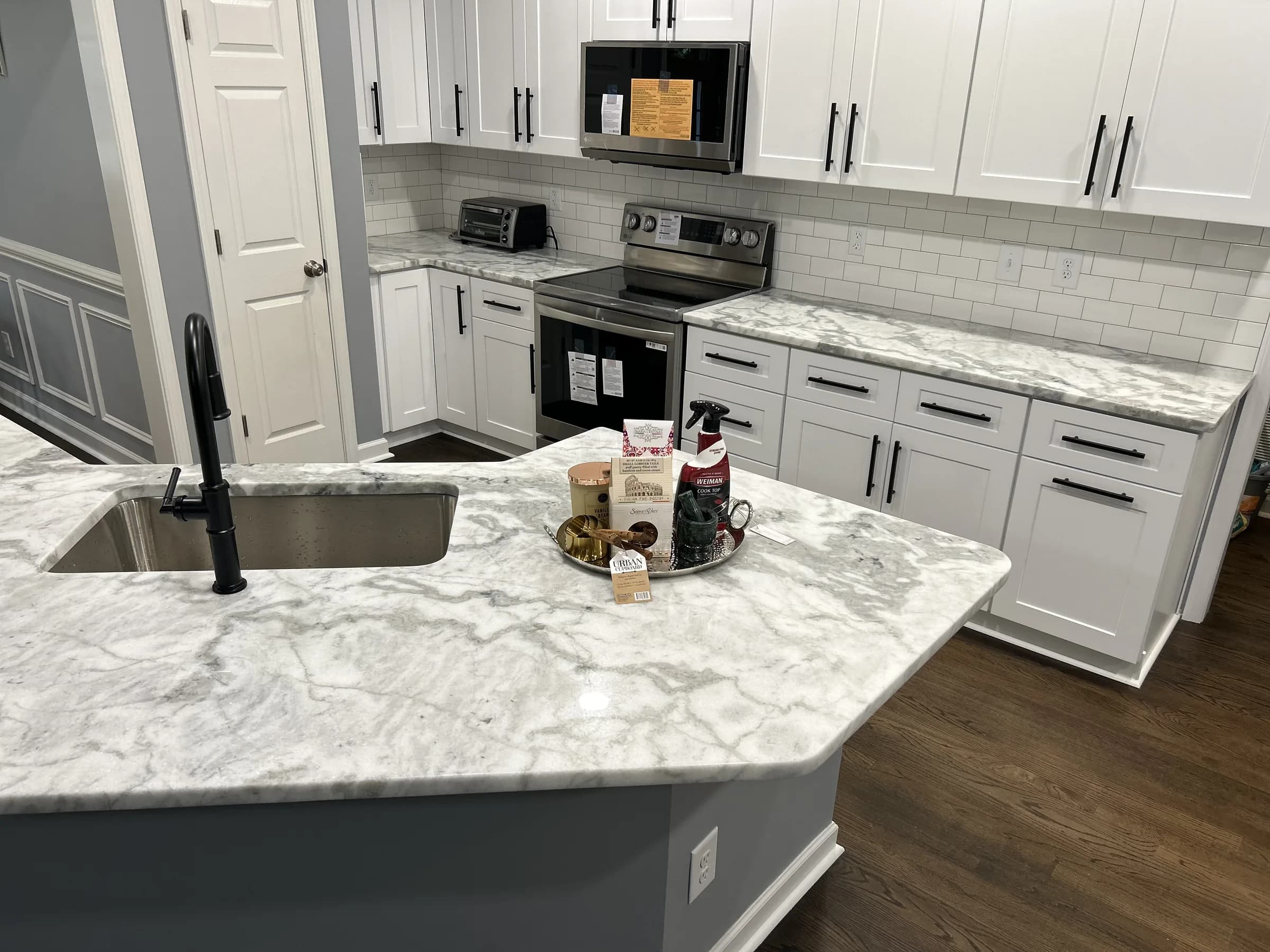 White shaker kitchen with veined marble counters and matte black faucet - photo 1