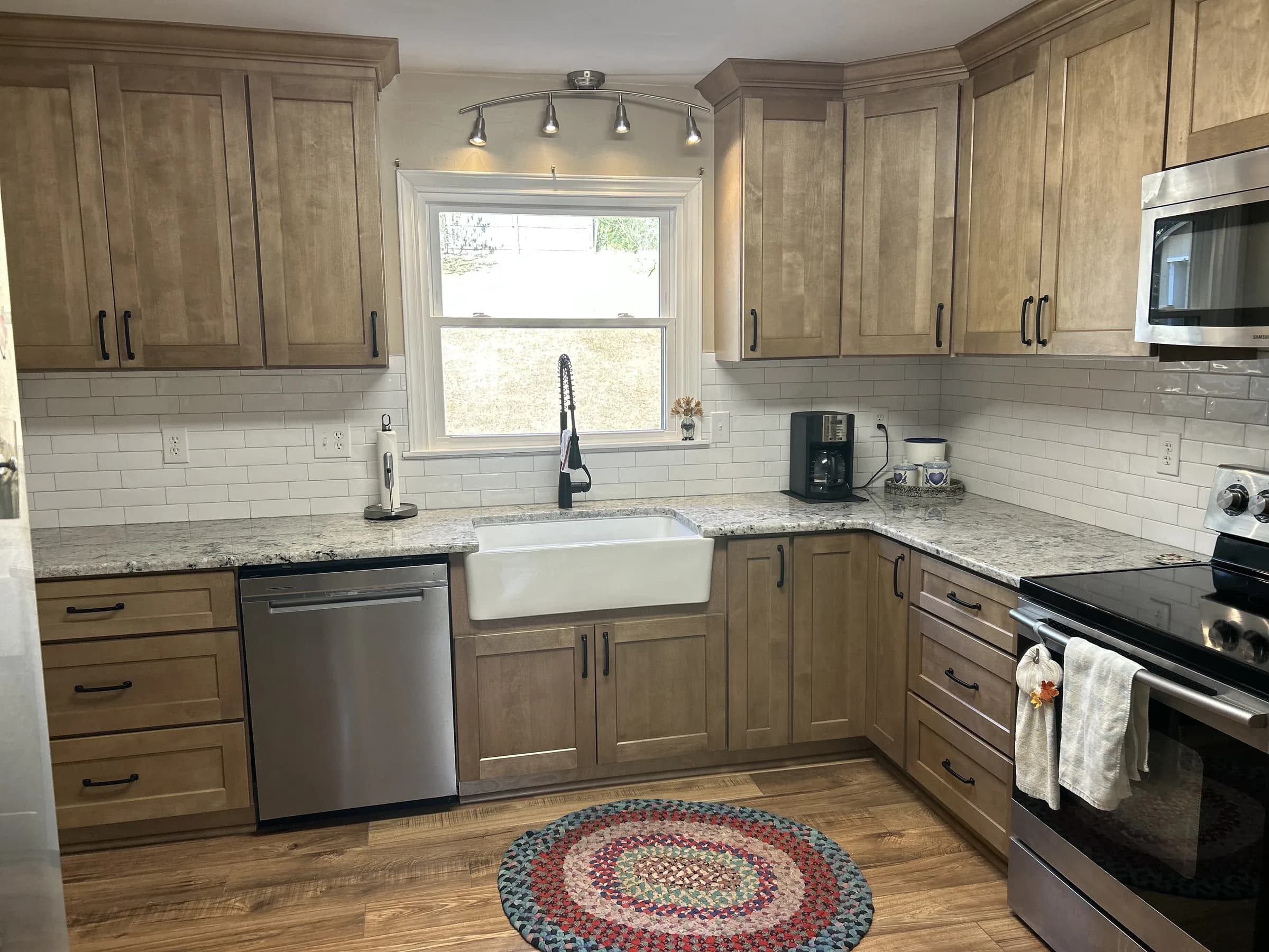 Warm-stained wood shaker kitchen with farmhouse sink and granite counters - photo 1