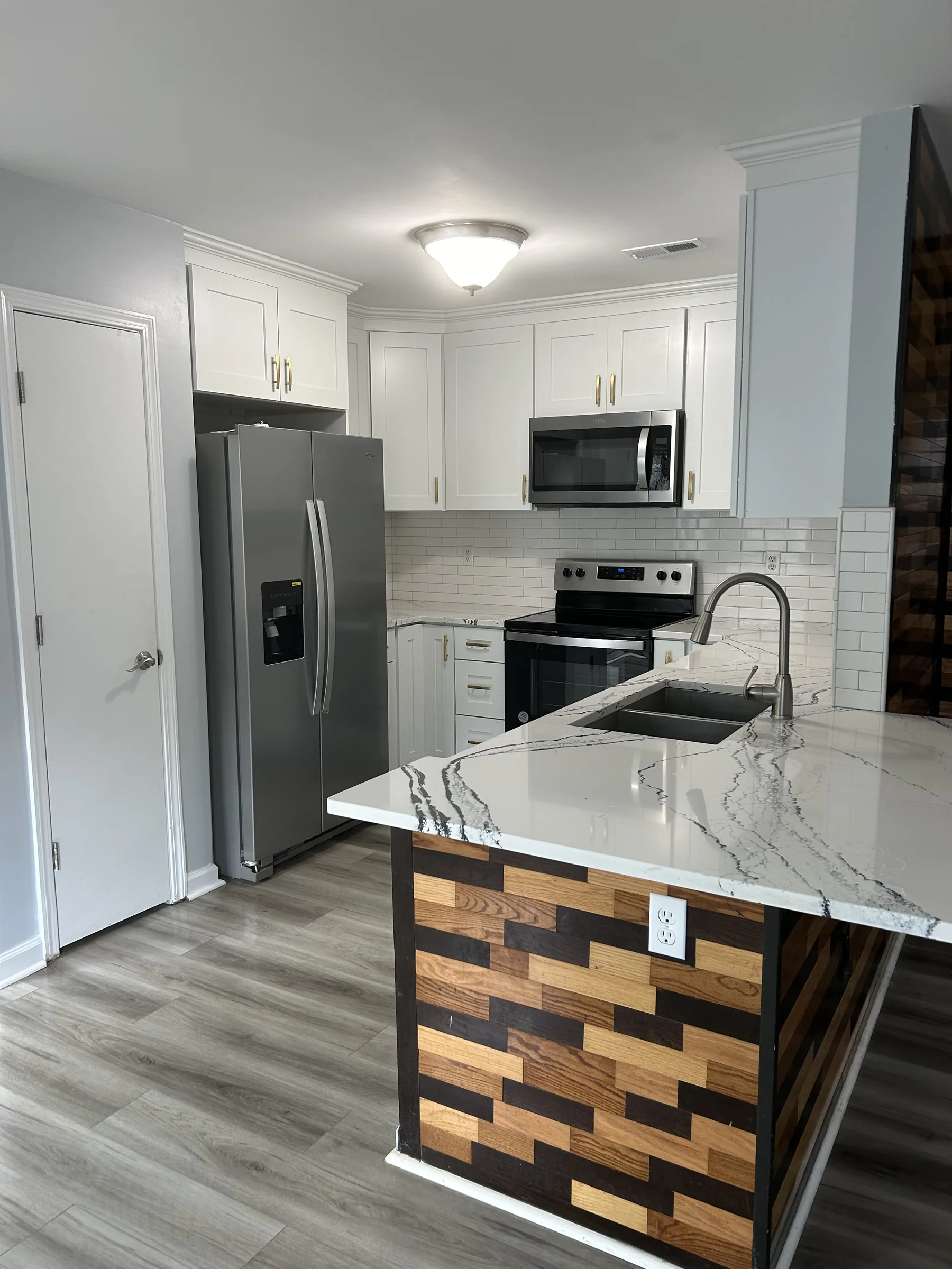 White shaker kitchen with custom geometric wood-block island panel and quartz counter - photo 1