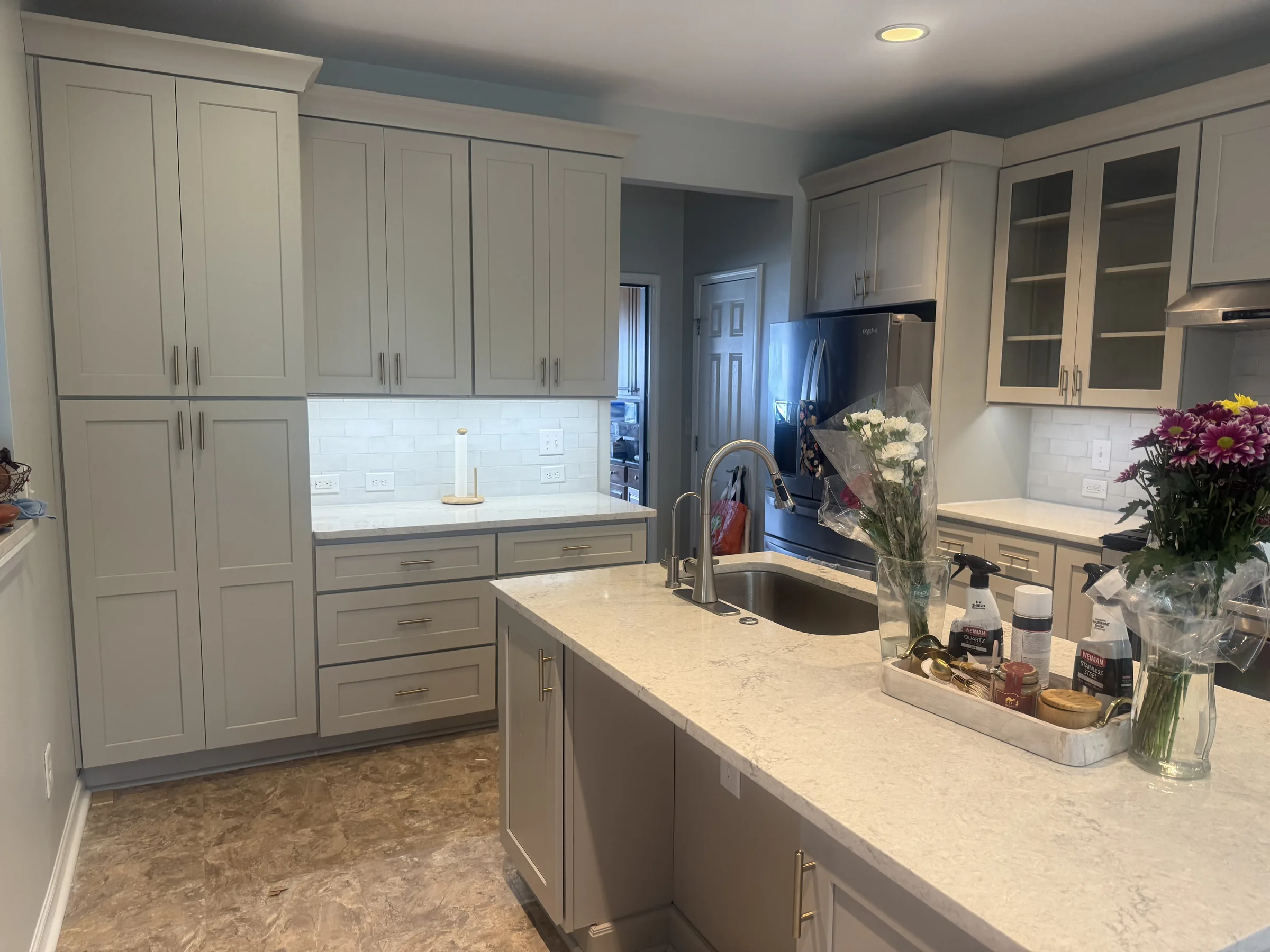 Light gray shaker kitchen with white quartz counters and brass pulls - photo 1