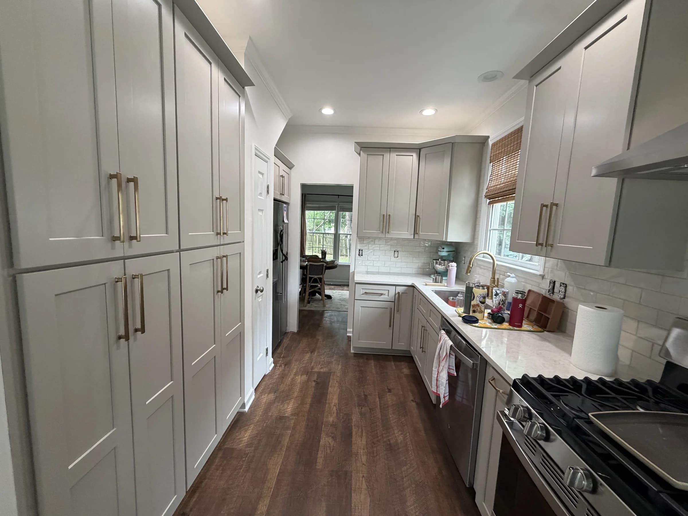 Apex kitchen remodel showing sand-colored Shaker pantry cabinets, quartz countertops and white subway tile